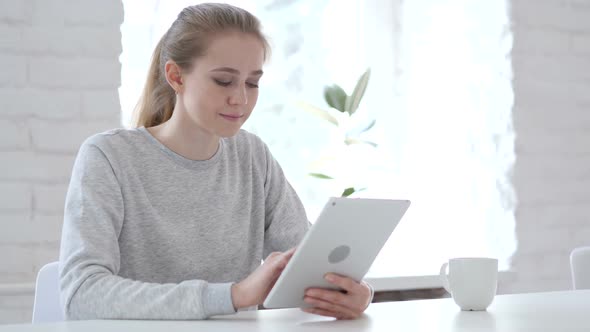 Young Woman Browsing and Scrolling on Tablet