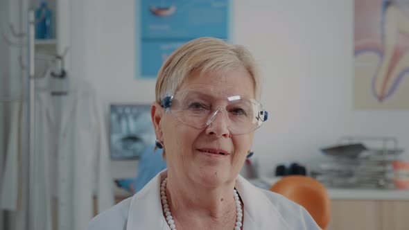 Portrait of Senior Dentist Sitting in Stomatology Office