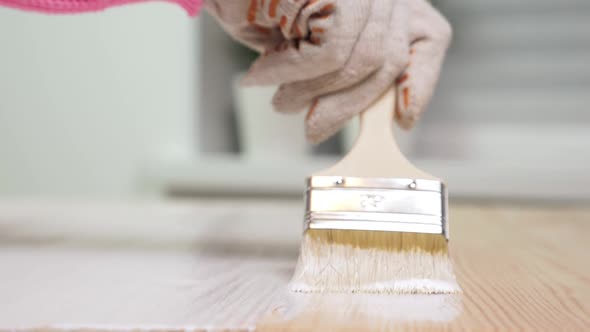 Woman Painting Wooden Table in White Color