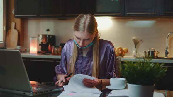 Woman in Pajama and with Medical Mask Signing Documents