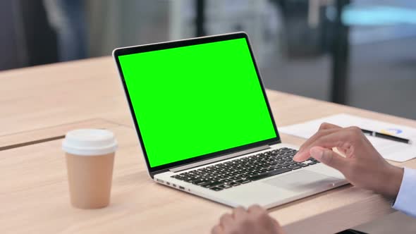 African Businessman Using Laptop with Green Screen