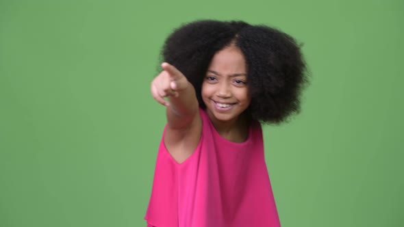 Young Cute African Girl with Afro Hair Laughing and Pointing Finger