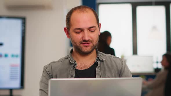 Enthusiastic Business Man Writing a Report Sitting at Table in Modern Start Up Business