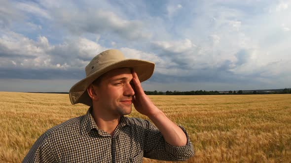 Close Up to Young Agronomist Standing on Barley Meadow and Looking at Cereal Plantation