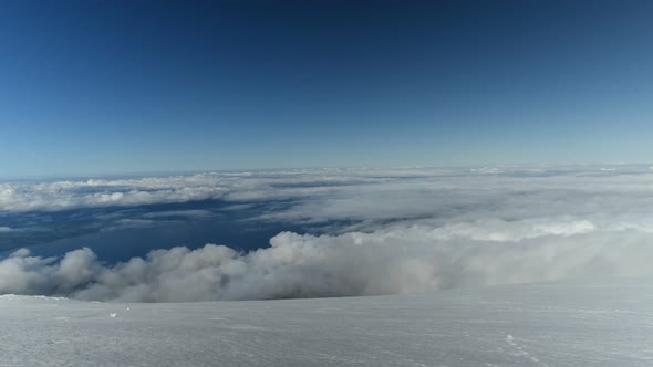 Clouds viewed from top of snow-covered mountain