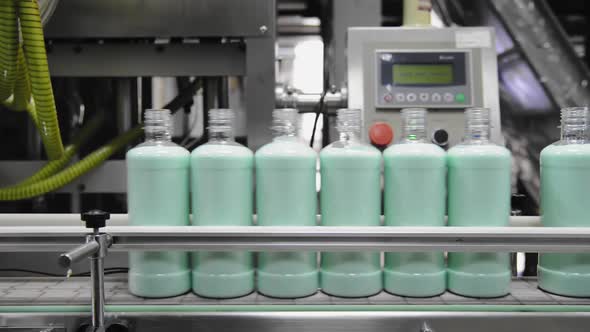 Conveyor of the production line with filling of transparent plastic bottles at the factory