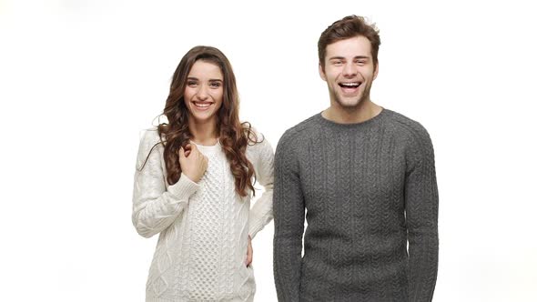 Slow Motion Young Happy Couple in Sweaters Natural Smiling on White Background.