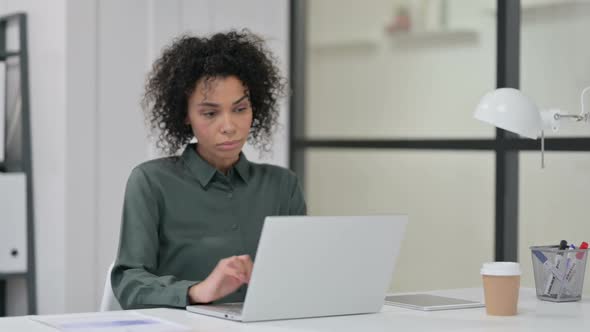 African Woman Closing Laptop and Leaving Office