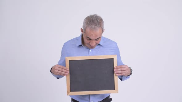 Happy Persian Businessman Holding Blackboard