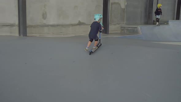 Boy Riding Scooter on Skating Playground