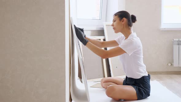 Painter in Tshirt Sits on Floor in Yoga Pose and Draws