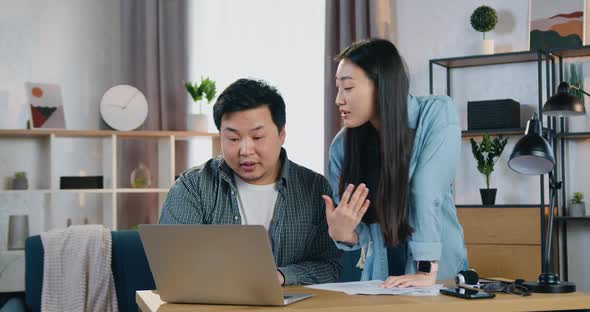 Asian Couple Working Together Over Startup Presentation and Revisioning Project on Computer