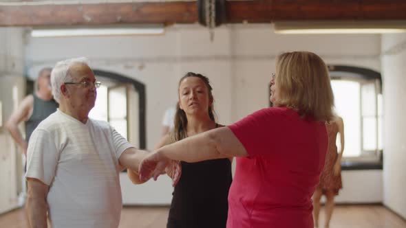 Front View of Dance Teacher Teaching Senior Couple How to Move