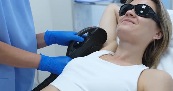 Woman Client in Protective Glasses Having Laser Hair Removal of Armpit in Beauty Salon  Movie