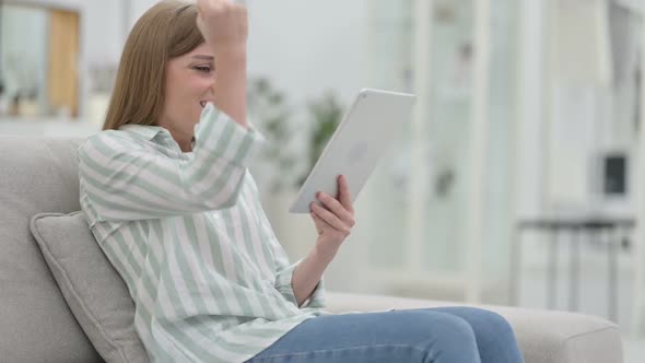 Excited Young Woman Celebrating Success on Tablet