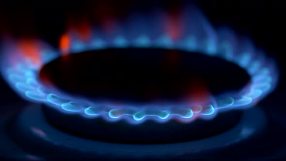 Gas Stove Firing Up with Blue Flame in the Darkness
