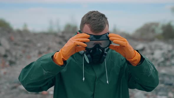 Portrait of man in the gas masks and protective clothes on the ruined background