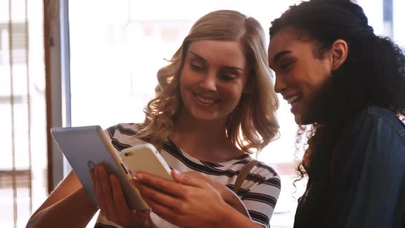 Handsome women using mobile phone and digital tablet