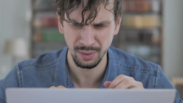 Loss Close Up of Tense Young Man Working on Laptop