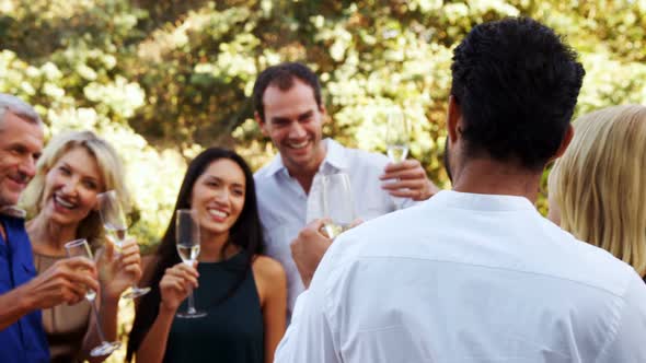 Friends interacting with each other while having champagne in balcony