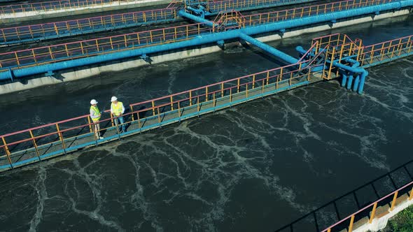 Workers Walking Along the Pipes at a Sewage Treatment Plant