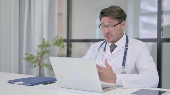 Doctor Talking on Video Call on Laptop in Clinic