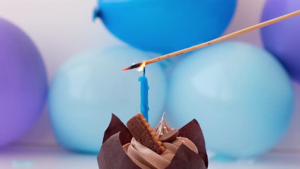 Sweet Tasty Chocolate Cupcake with Candle Burning on Blue Festive Background