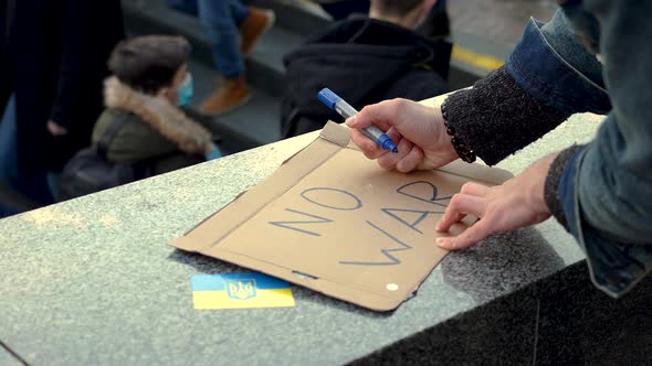 Preparing a protest sign for a demonstration against war in Ukraine.