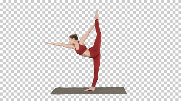 Slim woman standing in yoga pose dandayamana dhanurasana