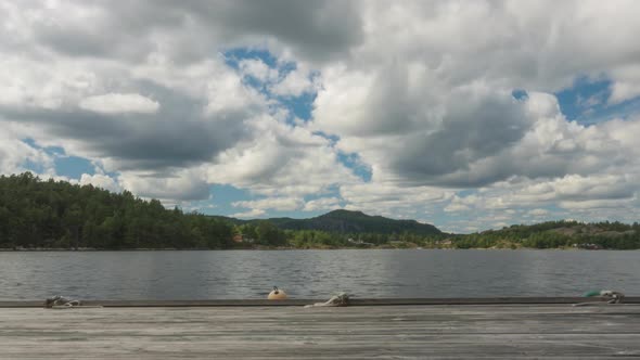 Dramatic time lapse over lake pier, moody skyscape in countryside