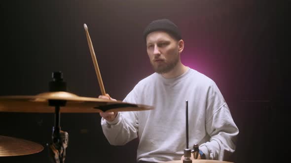 Drummer Playing the Drum Set in a Dark Room on a Black Background