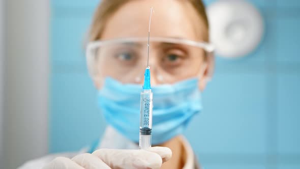 Blurred blonde nurse in blue disposable face mask and glasses