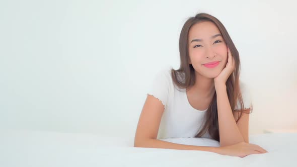 Asian woman relax on bed in bedroom interior