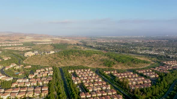 Aerial landscape pan over rows of similar houses in a modern residential estate