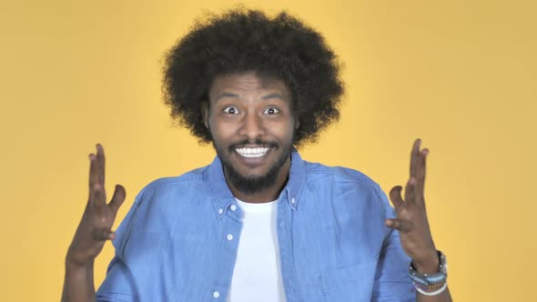 AfroAmerican Man Celebrating Success on Yellow Background