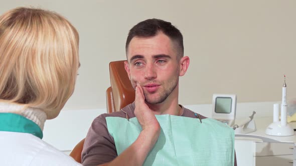 Male Patient with Toothache Talking To His Dentist at the Hospital