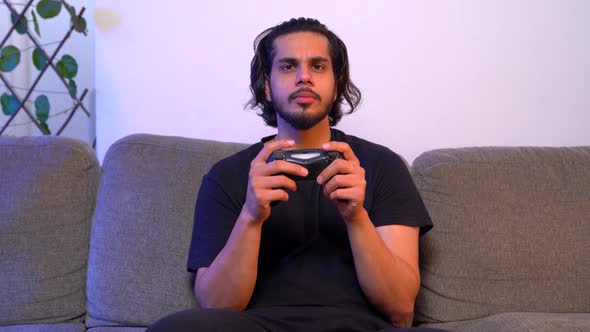 Serious Indian gamer playing video games late at night