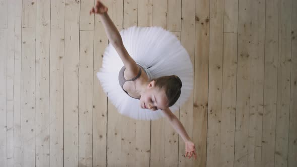 Top View Of Graceful Little Ballerina Dancing In Studio