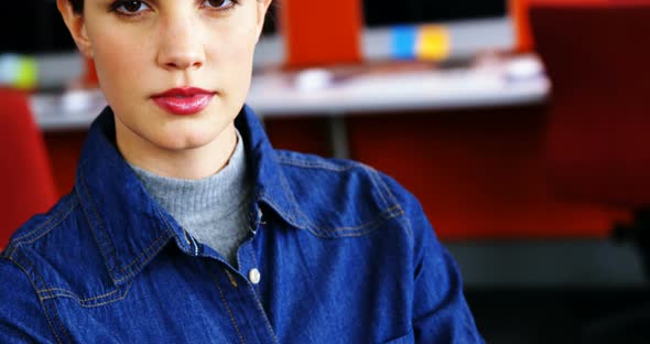 Portrait of female executive standing with arms crossed