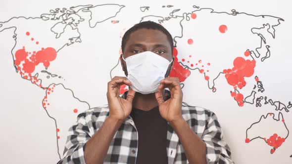 African American Male in Medical Mask and World Map That Shows Spreading of Coronavirus.