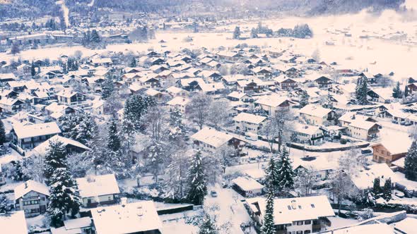 Car driving through snowy town of Garmisch-Partenkirchen, drone shot.