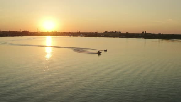 People are Riding on an Inflatable Circle Attached to a Water Scooter