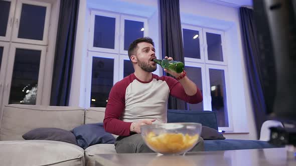 Man which Encouraging His Favourite Team on TV and Enjoying Beer Together 