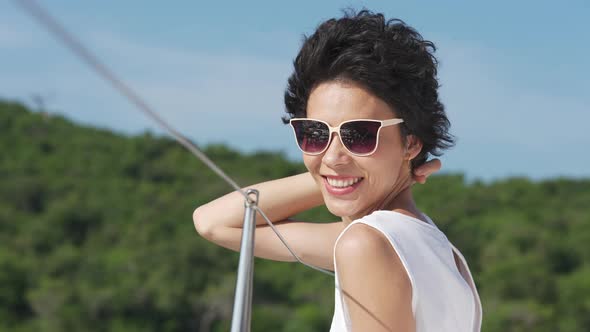 4K Portrait of Caucasian woman enjoy travel catamaran boat sailing in the sea at summer sunset.