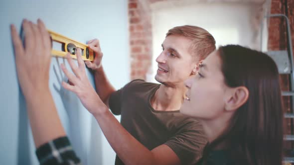 Close Up of Young Couple Using Waterpas Doing Renovation at Home