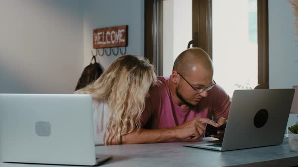 Freelancers man and woman work in cafe with laptop using laptop browsing online.