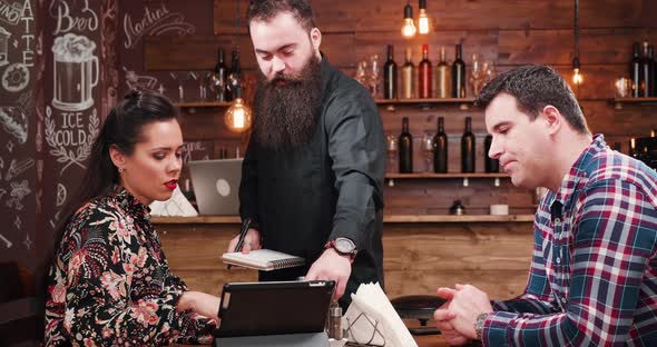 Couple Ordering To a Bearded Waiter