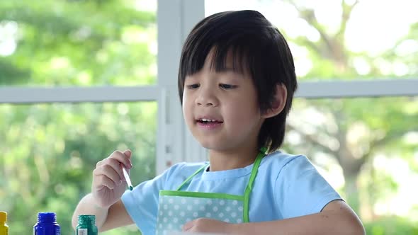 Cute Asian Boy Painting A Picture