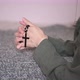 Woman brunette prays holding black rosary with cross in hands and kissing symbol standing on knees - VideoHive Item for Sale