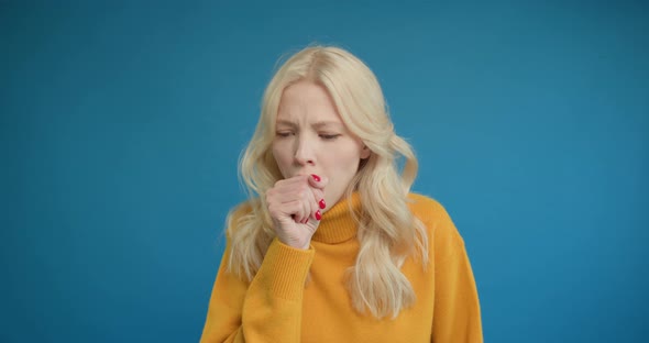 Young 25s Woman is Suffering with Cough and Feeling Bad Over Isolated Blue Background